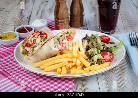 Gesundes Essen. Chicken Wrap mit Gemüse. BBQ Chicken mit frischem Salat Tortilla Wraps auf rustikalen Hintergrund. Stockfoto