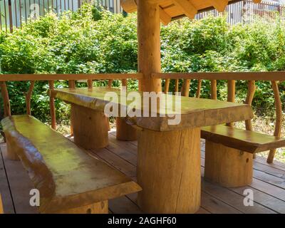Ein Tisch und zwei Bänke von großen Massivholz in einem Blockhaus gemacht Stockfoto