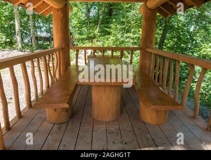 Ein Tisch und zwei Bänke von großen Massivholz in einem Blockhaus gemacht Stockfoto