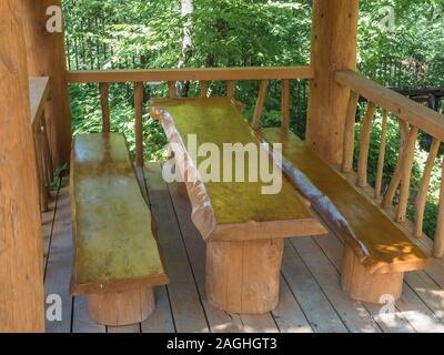 Ein Tisch und zwei Bänke von großen Massivholz in einem Blockhaus gemacht Stockfoto