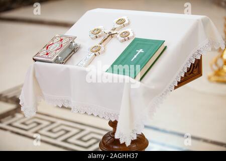 Das Sakrament der Ritus der Taufe eines Kindes in einem orthodoxen christlichen Kirche. Chan für die Waschung und Altar mit einer Bibel Stockfoto