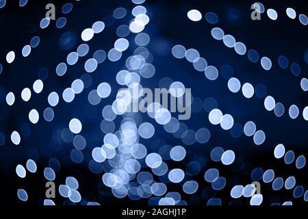Trendfarbe des Jahres 2020. Foto blau Bokeh leuchtet auf schwarzem Hintergrund. Perfekt für Overlay. Stockfoto