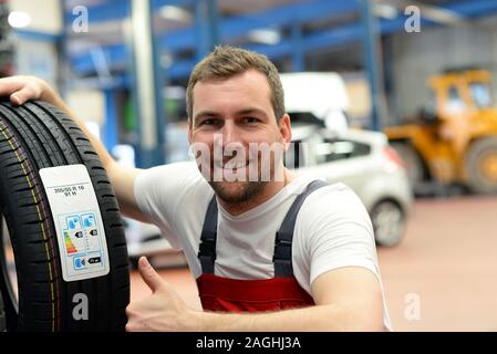 Wirtschaft Aufkleber mit Verbrauchswerte auf einem neuen Auto Reifen - Reifenwechsel in der Werkstatt durch mechanische Mittel Stockfoto