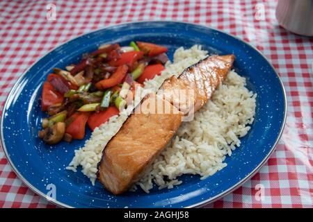 Teriyaki gegrillter Lachs auf weißem Reis mit sautierten Gemüse in Camping Stockfoto