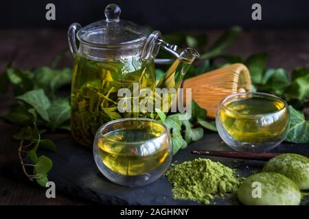 Traditionelle japanische Tee Matcha und Sencha aus Glas Teekanne mit bambusbesen und süßer Reis Kuchen mochi Stockfoto