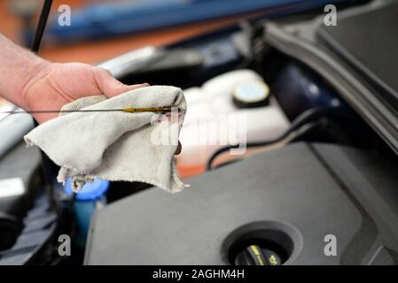 Arbeiten in einer Garage - Arbeiter steuert und ändert die Motoroel Stockfoto