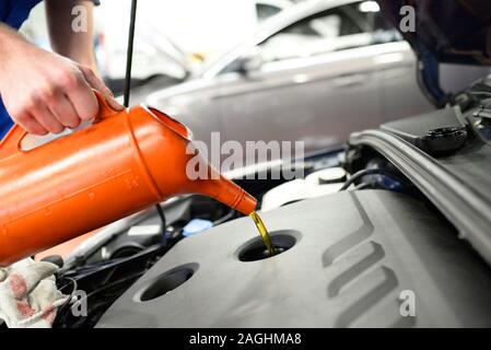 Arbeiten in einer Garage - Arbeiter steuert und ändert die Motoroel Stockfoto