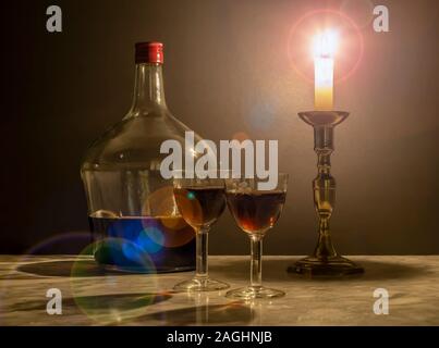 Süße Muscat Wein mit zwei alten Kristallgläsern bei Kerzenschein. Stockfoto