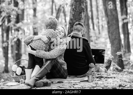 Glücklich, der Sohn mit den Eltern im Herbst Wald entspannen. Mutter, Vater lieben ihren kleinen Jungen Kind. Herbst Wetter. Wein oder Kaffee trinken. Frühling Stimmung. Happy f Stockfoto