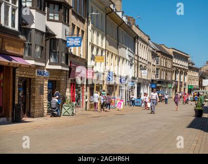 Käufer und lange Reihe von traditionellen Fronten in Fußgängerzone Hohe Straße an einem sonnigen Sommertag, Stamford, Lincolnshire, England, Großbritannien Stockfoto