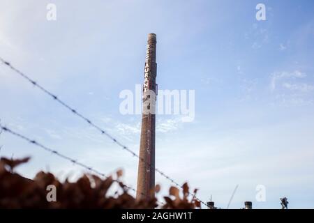 Alte langen gemauerten Schornstein mit den Worten Restaurant gegen den blauen Himmel, alte Fabrik industrie Stockfoto