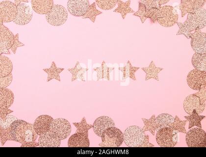 Rosa Konfetti in der Form eines Stern auf einem rosa Hintergrund. Weihnachten und Neujahr Konzept. Festliche Preisverleihung oder Bewertung Konzept. Fünf Sterne. Stockfoto