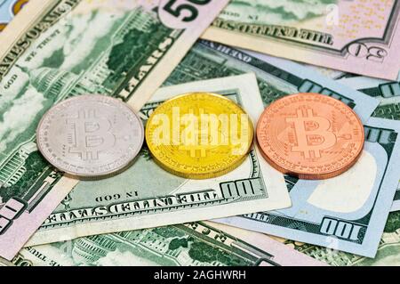 Silber, Bronze und gold bitcoin Münzen auf hundert und fünfzig Dollar Scheine. Stockfoto