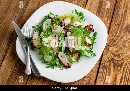 Meeresfrüchte Vorspeise. Oktopus Salat auf Holz- Hintergrund. Mediterrane Delikatesse. Selektiver Fokus Stockfoto