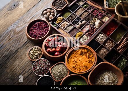 Festlegen von bunten Gewürzen in verschiedenen Schalen auf Holztisch. Ansicht von oben. Stockfoto
