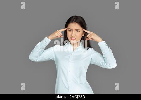 Freestyle. Junge Frau steht auf grau auf Kopf isoliert gereizt Stockfoto