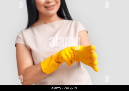 Freestyle. Asiatische Frau setzen auf Handschuhe weiss isoliert Aufstehen verschwommenes Lächeln glücklich Stockfoto