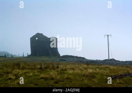 Abgebrochene verwinkelten Haus oberhalb einer Steigung an Croesor Schiefergrube im Norden von Wales im frühen Morgennebel Stockfoto