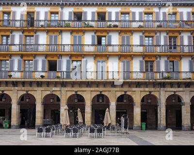 Chromrahmen, restaurant Stühle in einem öffentlichen Platz mit nummerierten Balkone in San Sebastian, Spanien, Europa gestapelt Stockfoto