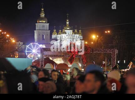 Kiew, Ukraine. 19 Dez, 2019. Blick auf St. Michael's Golden-Domed Kloster im Hintergrund während der Zeremonie der wichtigsten Weihnachtsbaum auf St. Sophia in Kiew. Die wichtigsten Weihnachtsbaum des Landes, deren Höhe mehr als 20 Meter hoch, ist mit etwa Tausend themed Spielwaren und ca. 4 km von bunten Girlanden dekoriert, entsprechend dem offiziellen Portal der ukrainischen Hauptstadt. Riesige Figuren der Nussknacker und Helden der animierten Serie über kosaken "Guard" der Weihnachtsbaum. Die Eröffnung der Ukrainischen main Weihnachtsbaum 2020 fand am 19. Dezember Stockfoto