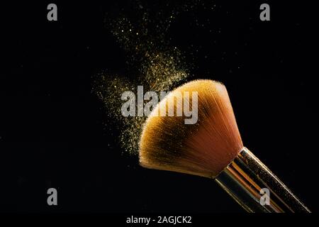 Make-up-Pinsel auf Schwarz. Vorderansicht. Fallende funkelt. Durch die Farbe des Jahres 2020 Ispired Stockfoto
