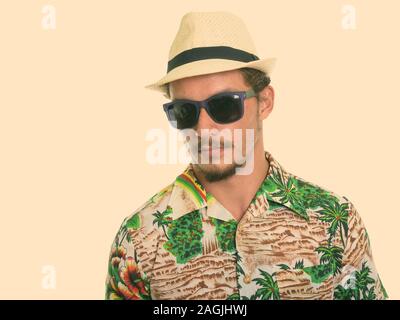 Studio shot der jungen schönen touristischen Mann mit Sonnenbrille vor weißem Hintergrund Stockfoto