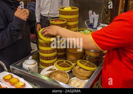 Chinesische serviert Kellnerin dimsum in Bambus steamer Boxen in Restaurant Stockfoto