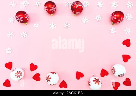 Weihnachten Komposition. Weihnachten Kugeln, rote Herzen und Schneeflocken Dekorationen auf rosa Hintergrund. Flach, Ansicht von oben, kopieren Raum Stockfoto