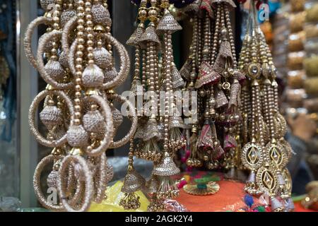 Bunt metallic Dekorationen auf Anzeige zum Verkauf in Chandi Chowk Old Delhi. Diese Blumen, Perlen und Glocken Designs sind beliebt in Hochzeiten, Feste Stockfoto