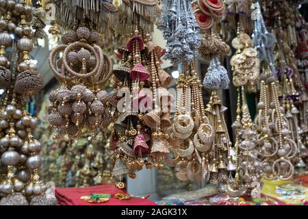 Bunt metallic Dekorationen auf Anzeige zum Verkauf in Chandi Chowk Old Delhi. Diese Blumen, Perlen und Glocken Designs sind beliebt in Hochzeiten, Feste Stockfoto