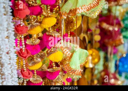 Bunte Gewebe Dekorationen auf Anzeige zum Verkauf in Chandi Chowk Old Delhi. Diese Blumen, Perlen und Glocken Designs sind beliebt in Hochzeiten, Feste ein Stockfoto
