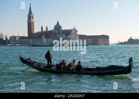 Touristische Reisen in einer Gondel vor der Insel San Giorgio Maggiore in Venedig, Italien. Stockfoto