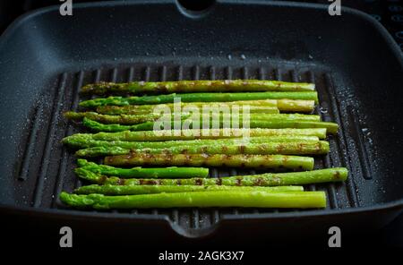 Gegrillter Spargel. Gebratener Spargel in der Pfanne. Gegrilltes Gemüse auf dem Grill. Veg Konzept. Stockfoto