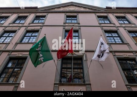 Schweizer und Kanton Flaggen hängen auf der Fassade Gebäude in einem windigen Tag in St. Gallen, Schweiz. Stockfoto