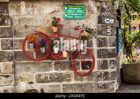 Mit Blumen und Wanderwegschildern dekoriertes Fahrrad in Sebnitz Stockfoto