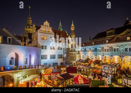 Bunt beleuchtete Mittelalterlicher Weihnachtsmarkt im Innenhof der Hausmannsturm Stallhof, Turm und die Kathedrale hinter Stockfoto