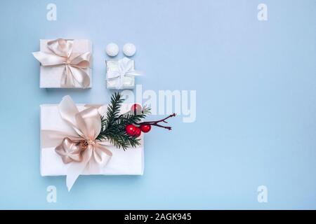 Geschenke mit Weihnachten Einrichtung in Weiß auf blauem Hintergrund. Minimalismus, Flach, Ansicht von oben, kopieren Raum Stockfoto