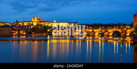 Prager Skyline und die Brücke über den Fluss in der Tschechischen Republik bei Nacht Panorama. Stockfoto