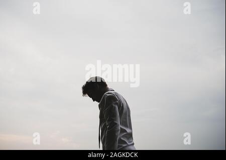 Junge Unternehmer außerhalb stehen unter bewölktem Himmel überarbeitet. Stockfoto