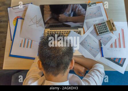 Blick von oben auf die Geschäftsmann, Schlafen, die auf Notebook- und Finanzunterlagen Stockfoto