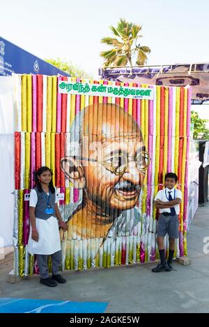 Schulmädchen und Schule Junge stellen neben einem Ghandi portrait in Puducherry, Tamil Nadu, Indien Stockfoto
