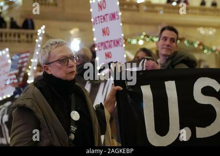 New York, New York/USA - Dezember 19, 2019: Aktivist aus der Gruppe steigen und widerstehen NYC hält ein Banner und schaut stoisch während einer stillen Protest ein Stockfoto