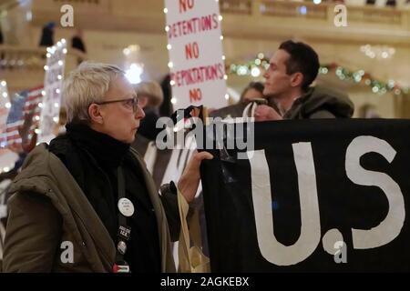 New York, New York/USA - Dezember 19, 2019: Aktivist aus der Gruppe steigen und widerstehen NYC hält ein Banner und schaut stoisch während einer stillen Protest ein Stockfoto