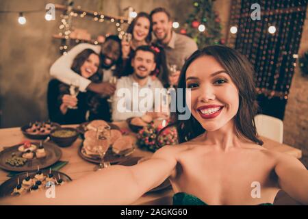 Nahaufnahme Foto, fröhliches Mädchen Gruppe von Menschen machen selfie Weihnachtsferien x-mas Party im Haus mit neujahr Beleuchtungslampen im Innenbereich Stockfoto