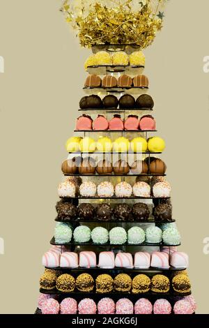 Der Tower oder die Pyramide und Cupcakes auf Süßes Dessert Tabelle. Süßigkeiten in verschiedenen stilvollen Bonbons für Verkauf Stockfoto