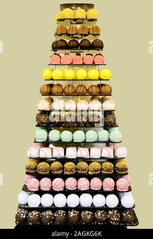 Der Tower oder die Pyramide und Cupcakes auf Süßes Dessert Tabelle. Süßigkeiten in verschiedenen stilvollen Bonbons für Verkauf Stockfoto