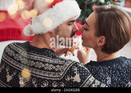 Für eine Sekunde vor einem Kuss. Feiern das neue Jahr. Klopfen Gläser. Schönes Paar im Urlaub Kleidung sitzt und Umarmungen. Foto von der Rückseite Stockfoto