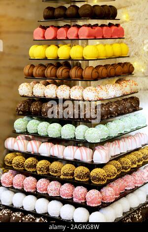 Der Tower oder die Pyramide und Cupcakes auf Süßes Dessert Tabelle. Süßigkeiten in verschiedenen stilvollen Bonbons für Verkauf Stockfoto