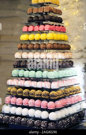 Der Tower oder die Pyramide und Cupcakes auf Süßes Dessert Tabelle. Süßigkeiten in verschiedenen stilvollen Bonbons für Verkauf Stockfoto