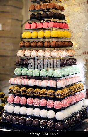 Der Tower oder die Pyramide und Cupcakes auf Süßes Dessert Tabelle. Süßigkeiten in verschiedenen stilvollen Bonbons für Verkauf Stockfoto